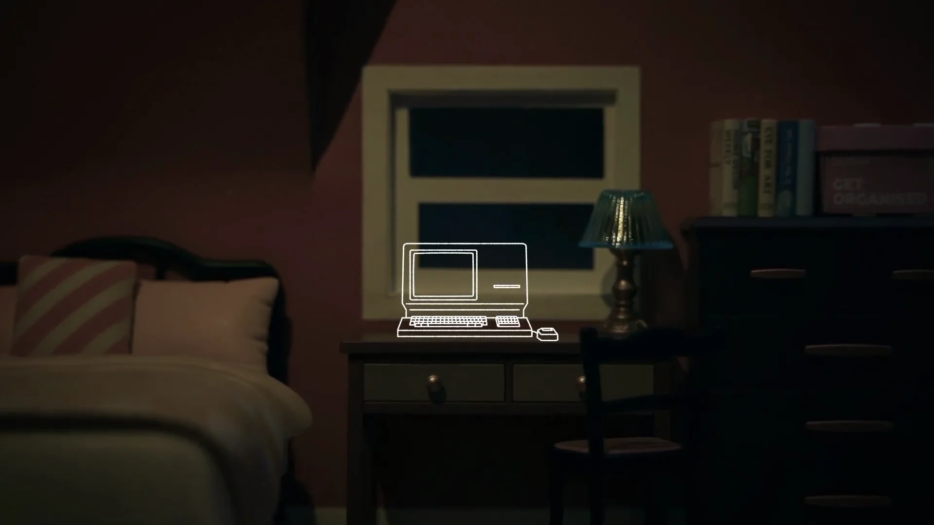 Capture de la vidéo : photographie d'un décor de chambre, un ordinateur tracé au trait blanc, donnant l'illusion qu'il est posé sur le bureau.